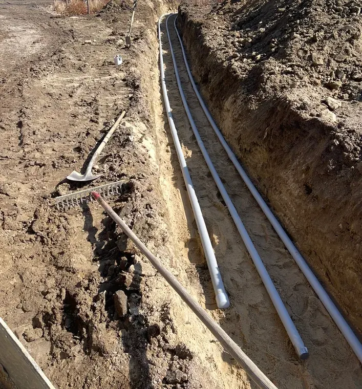 Conduit bedded in sand in the bottom of the trench