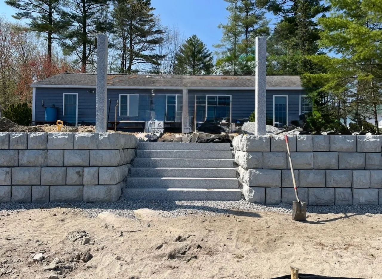 Retaining wall with granite steps and posts set into the run